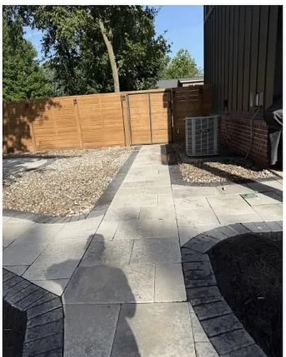 Paver landing laid beside an air conditioning unit against a wood fence
